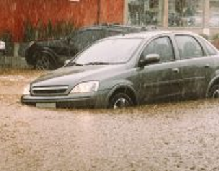 Unidentifiable passengers stuck in a car during heavy rains and flash flood - insurance claim concept