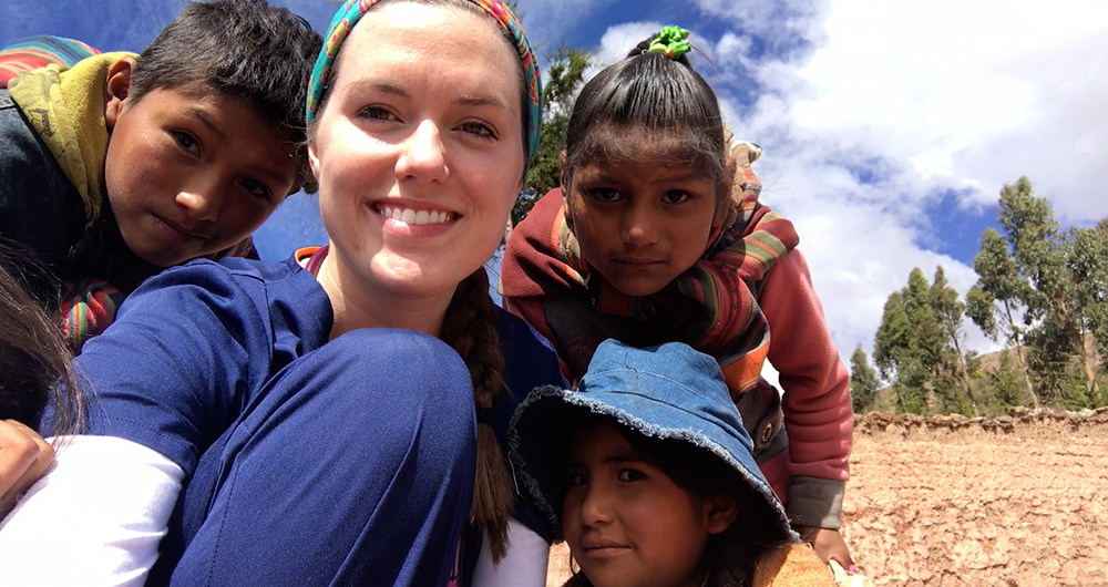 Student Hanna Himes posing with children during a mission trip to Bolivia