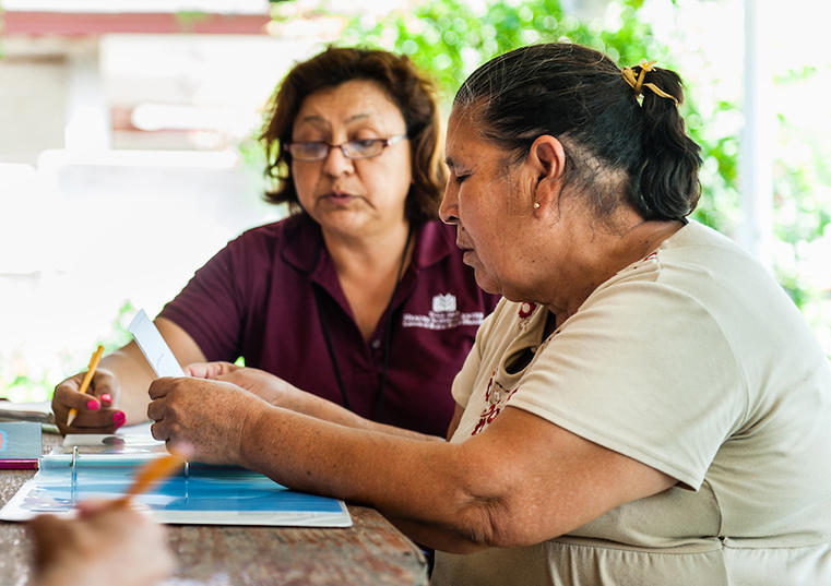 Health care worker reviewing literature with a patient at her rural home